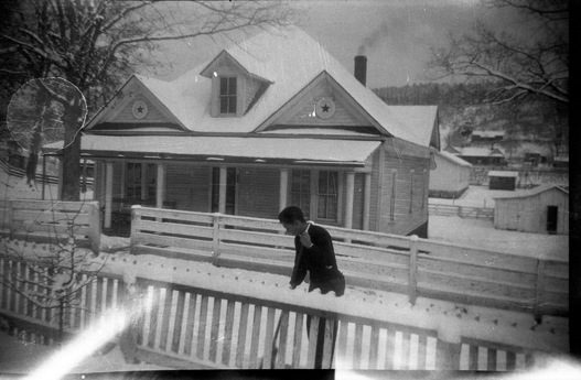 The Presbyterian manse at Lancing, next to the family, with Bill Scott shoveling snow