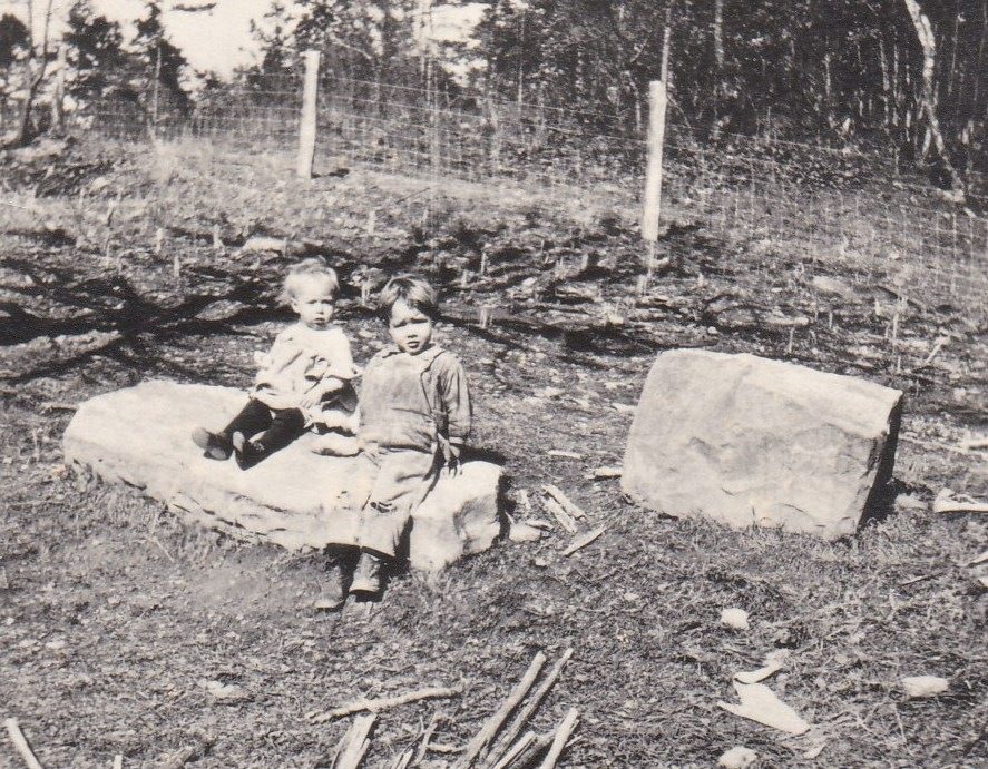 Russell (Gary's father) and Bill on a rock near the black walnut tree at Huffman, about 1922